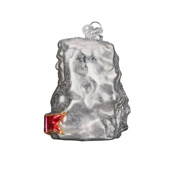Side view of Glass ornament in the shape of Mount Rushmore on a white background.