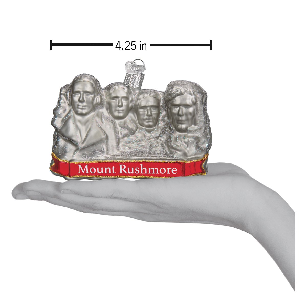 Glass ornament in the shape of Mount Rushmore in a hand showing dimensions against a white background.