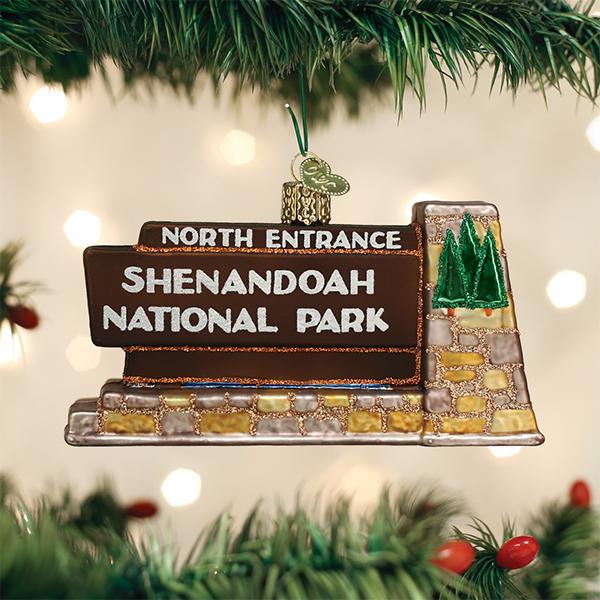 3-D glass ornament in the shape of the Shenandoah national park entrance sign against a festive background.