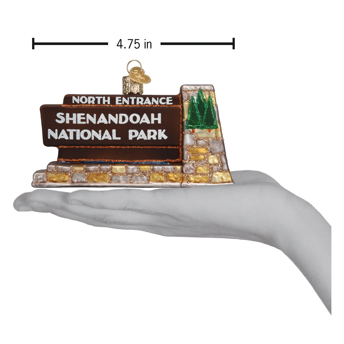 3-D glass ornament in the shape of the Shenandoah national park entrance sign in a hand to show size against a white background.