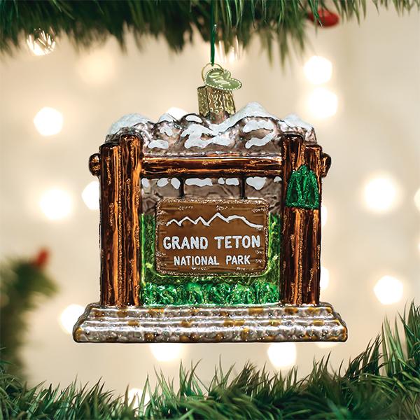 3-D glass ornament depicting the entrance sign of grand Teton national Park against a festive background