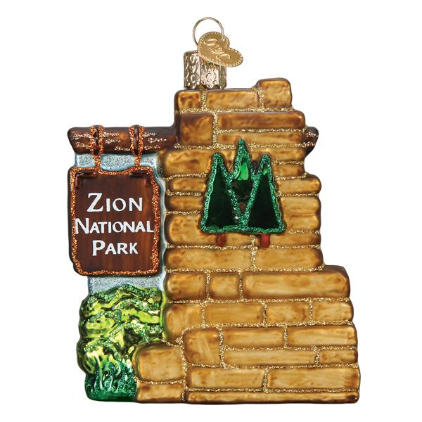 3-D glass ornament in the shape of the Zion national park entrance sign on a white background.
