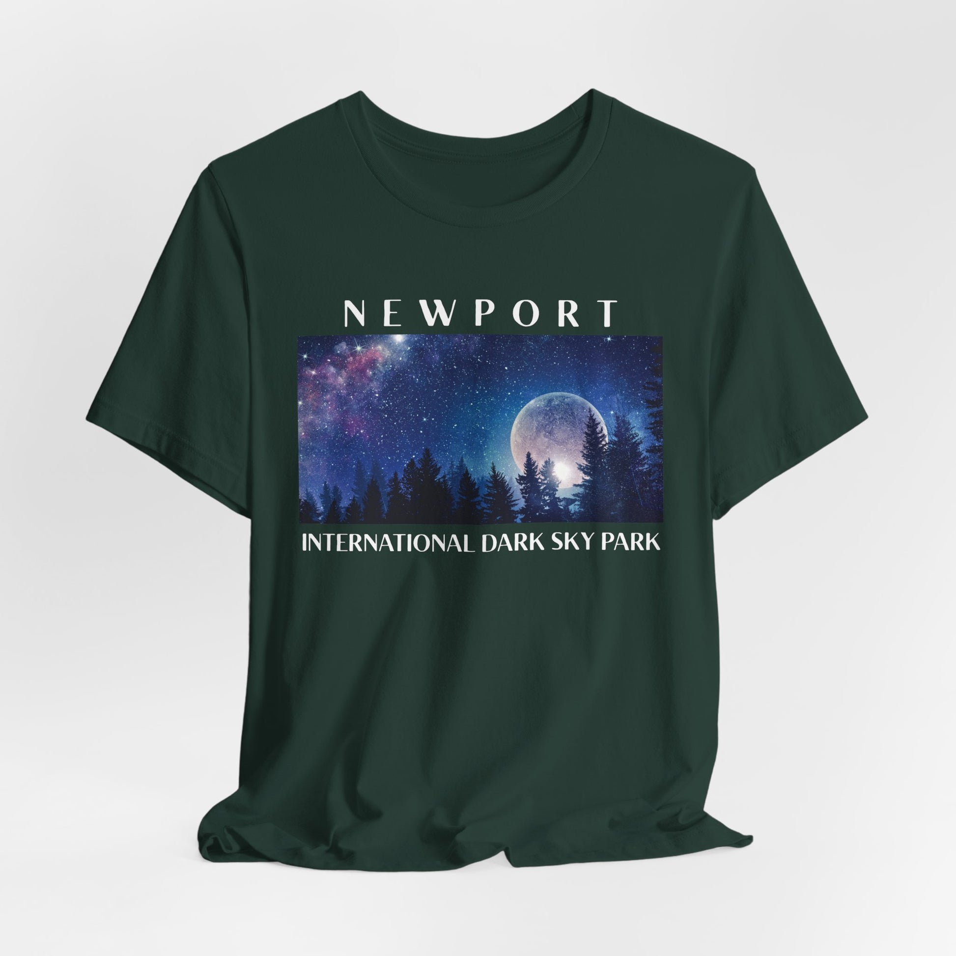 Forest green t-shirt with a graphic of a night sky over trees and the text 'Newport International Dark Sky Park'.
