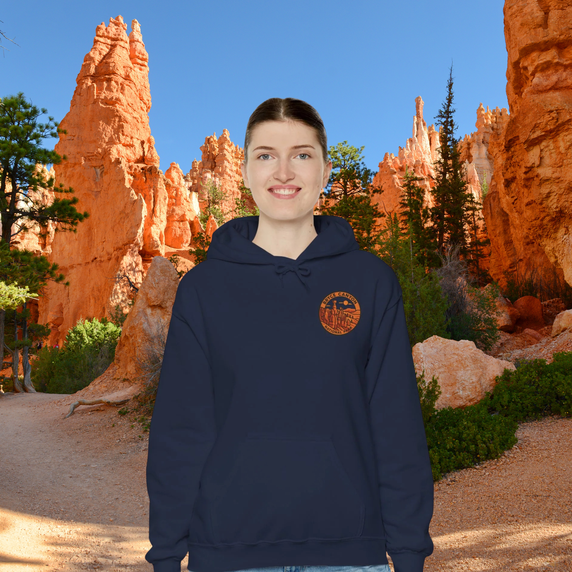Person wearing a navy hoodie with a Bruce Canyon National Park design in front of red rock formations
