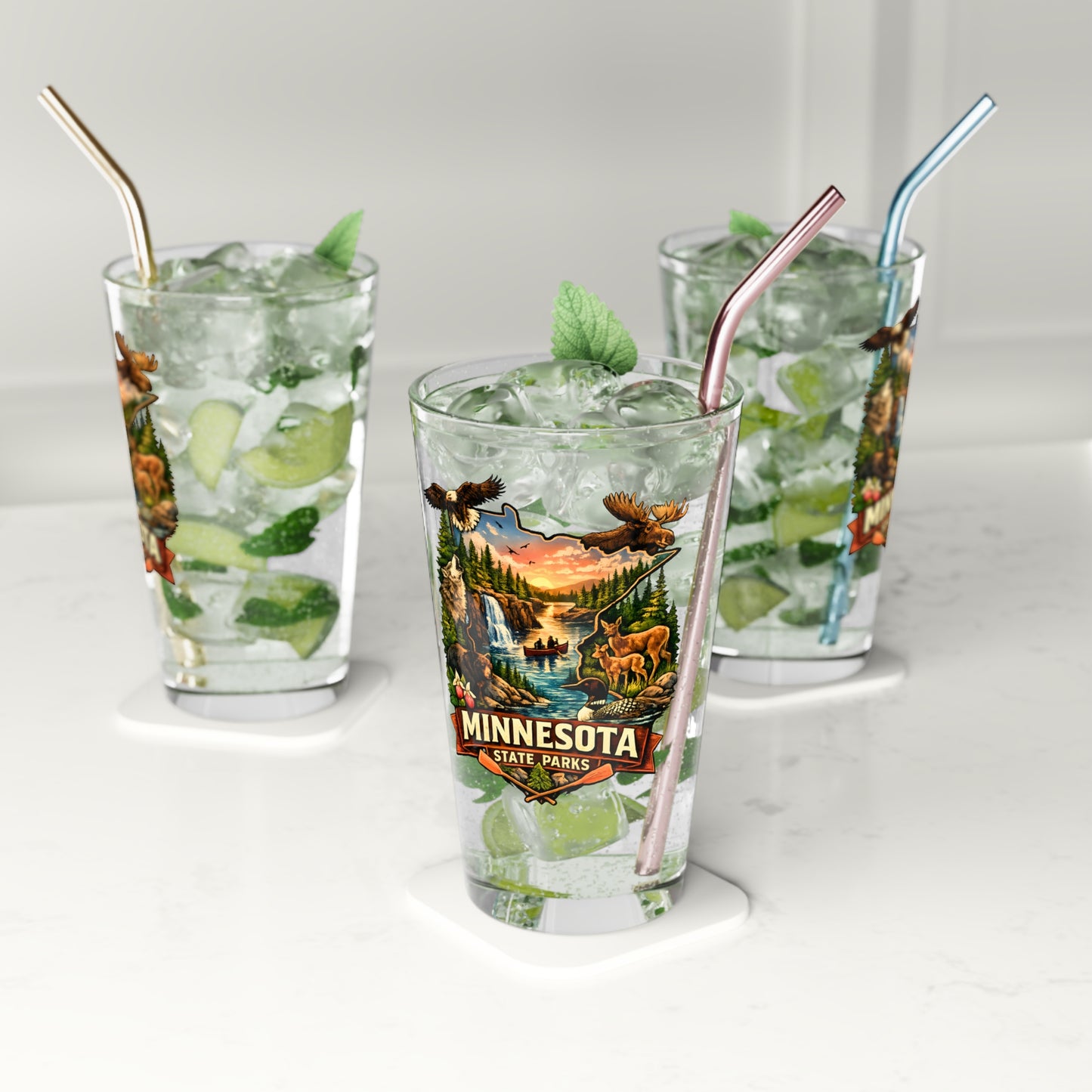 Three glasses of iced beverages with straws on a white surface, featuring a Minnesota State Parks design.