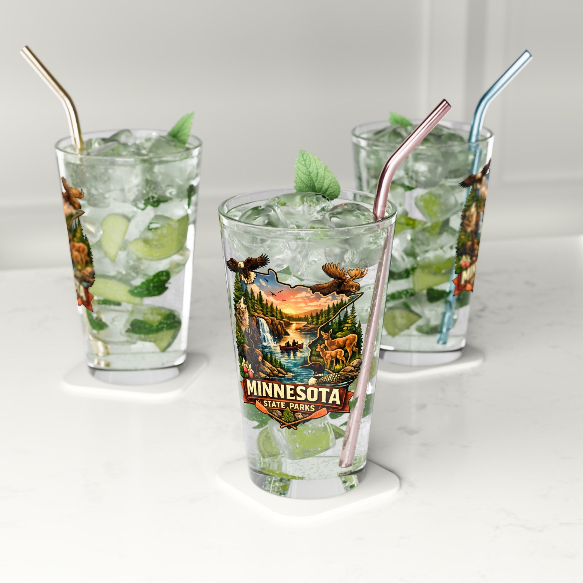 Three glasses of iced beverages with straws on a white surface, featuring a Minnesota State Parks design.