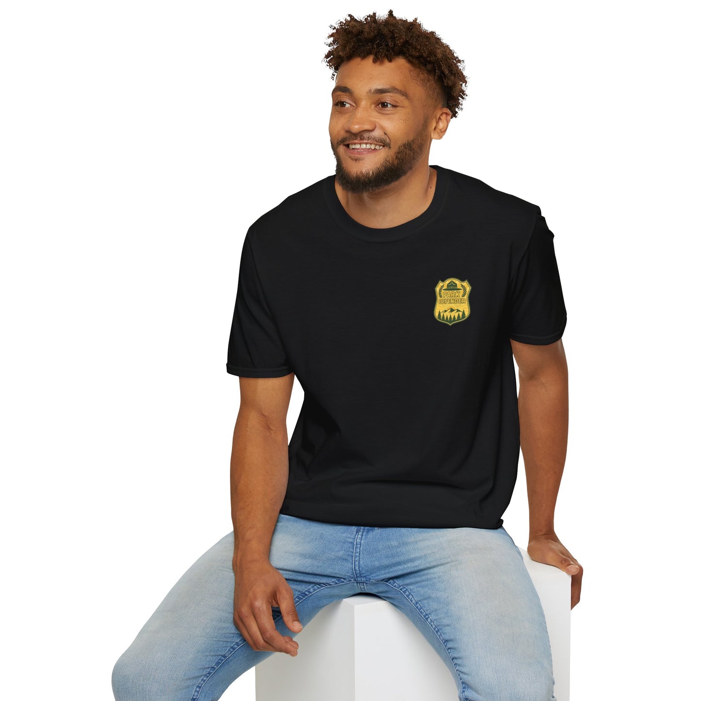 Man wearing a black t-shirt with a small badge graphic on a white background