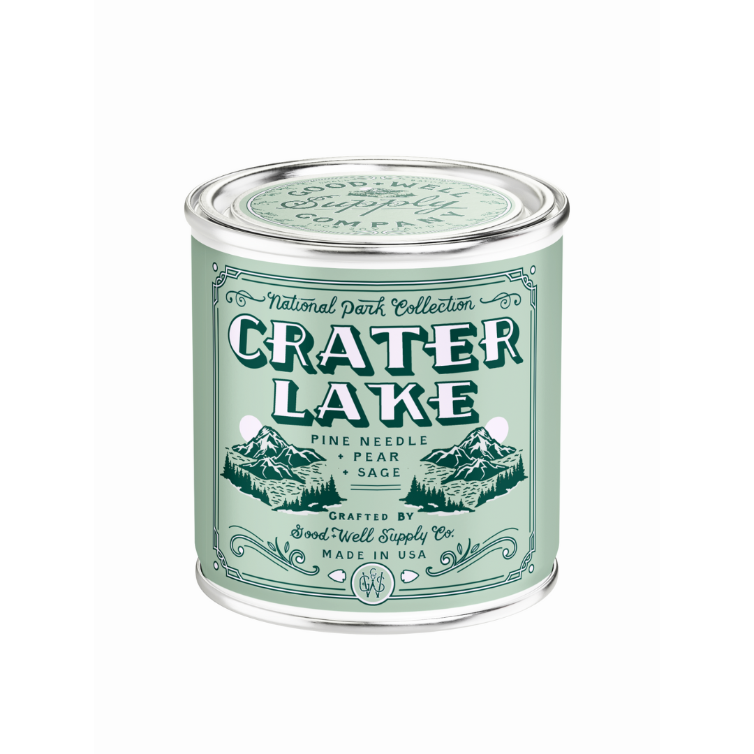Candle in a tin labeled 'Crater Lake' from the National Park Collection on a white background.