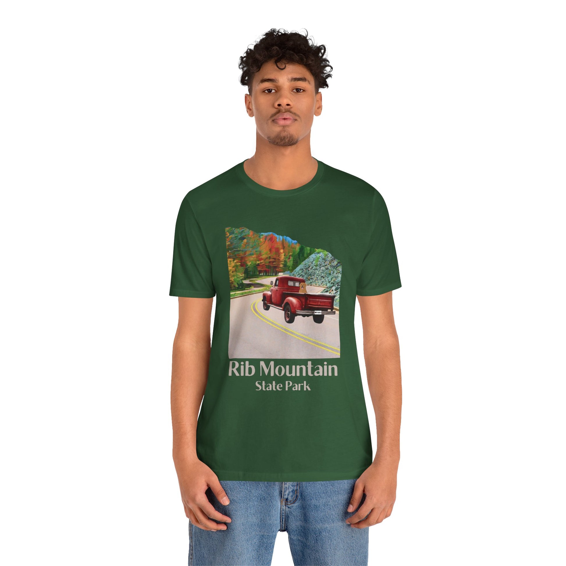 Male model wearing evergreen colored T-shirt with vintage truck driving up the road to Rib Mountain State Park during fall leaf color graphic.