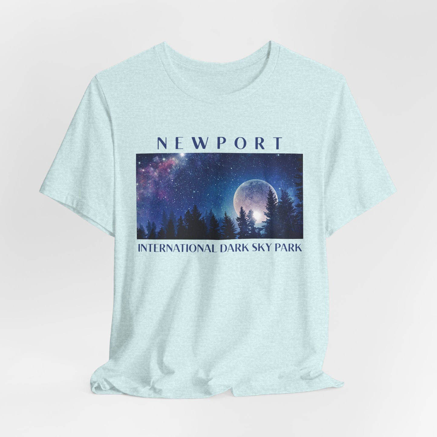 Heather prism ice blue t-shirt with a graphic of a night sky over trees and the text 'Newport International Dark Sky Park'.