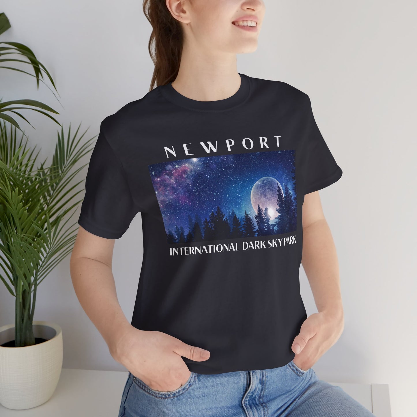 Person wearing a dark grey t-shirt with 'Newport International Dark Sky Park' design