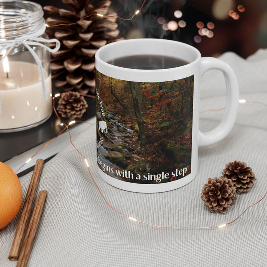 Mug with nature-themed design and text on a table with decorative items