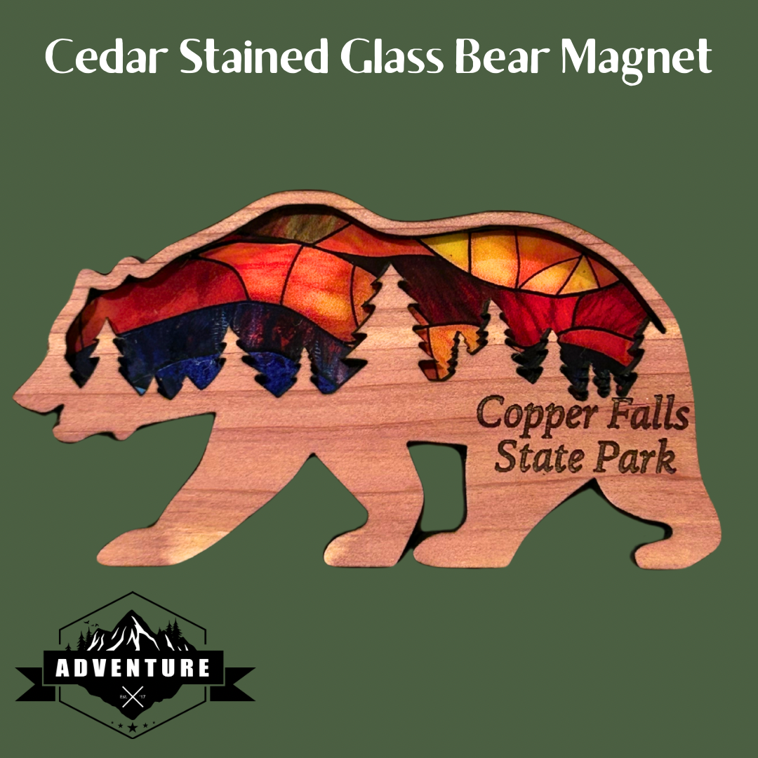 Bear shaped ornament made with cedar and a stained glass appearance.  Includes the text “Copper Falls State Park”.  Photo Background: green backdrop.