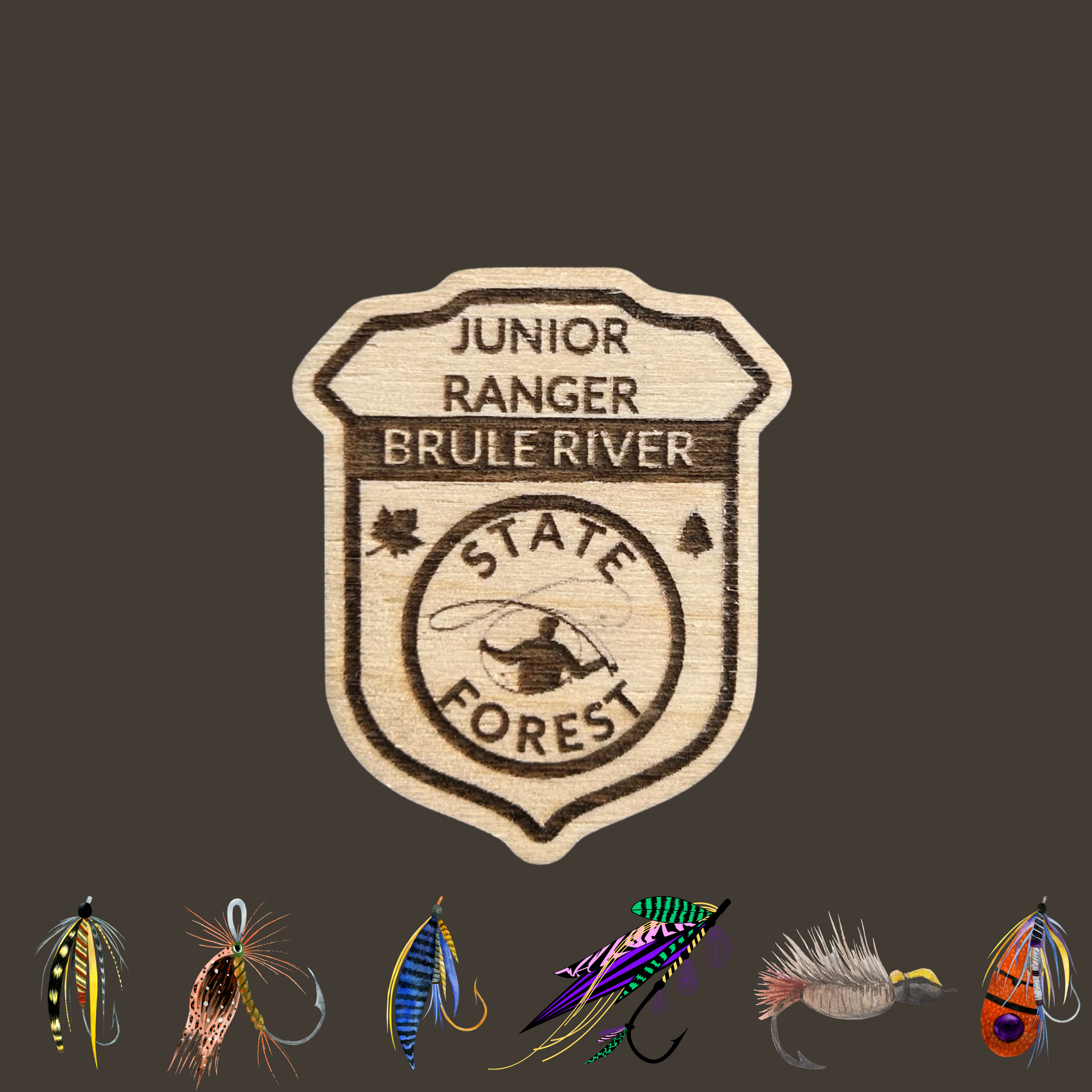 Wood Jr Ranger badge with the text: “Junior Ranger Brule River State Forest” and an icon of a fly fisherman casting.  Photo background: dark grey background with 6 icons of different types of fly fishing flies. 