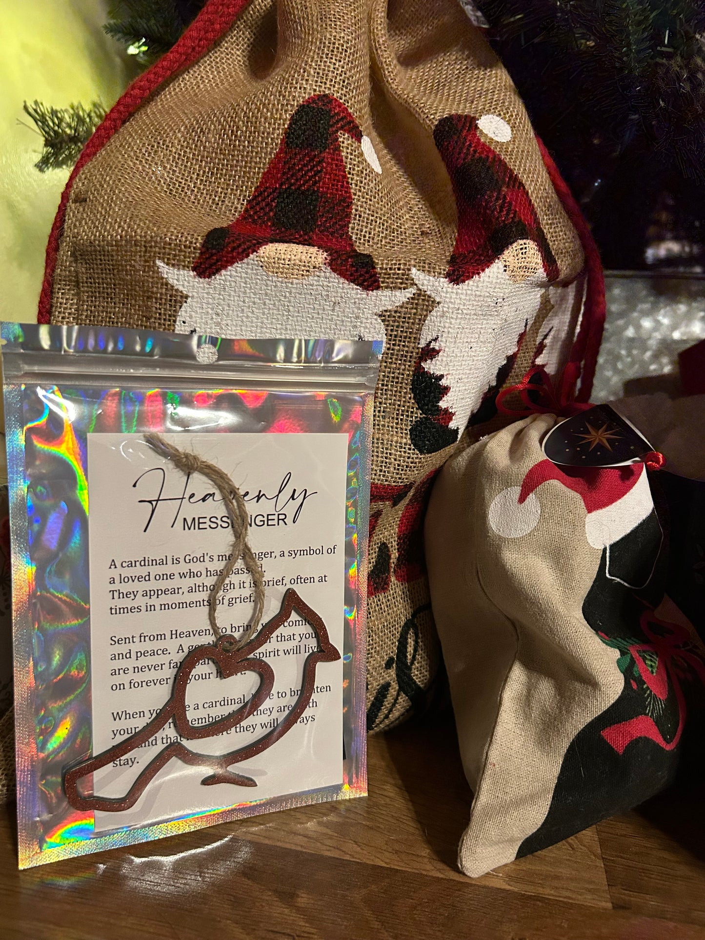 Packaged cardinal ornament under a tree with other gifts.