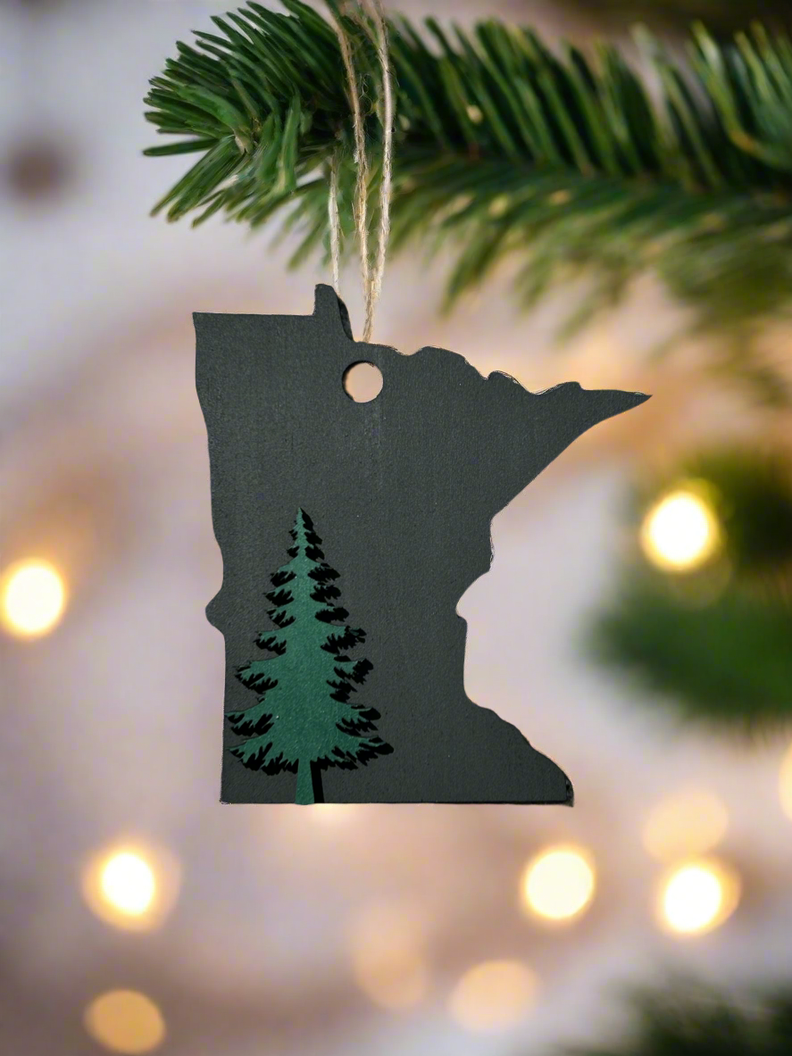Black Minnesota Shaped ornament with a green pine tree icon. 
