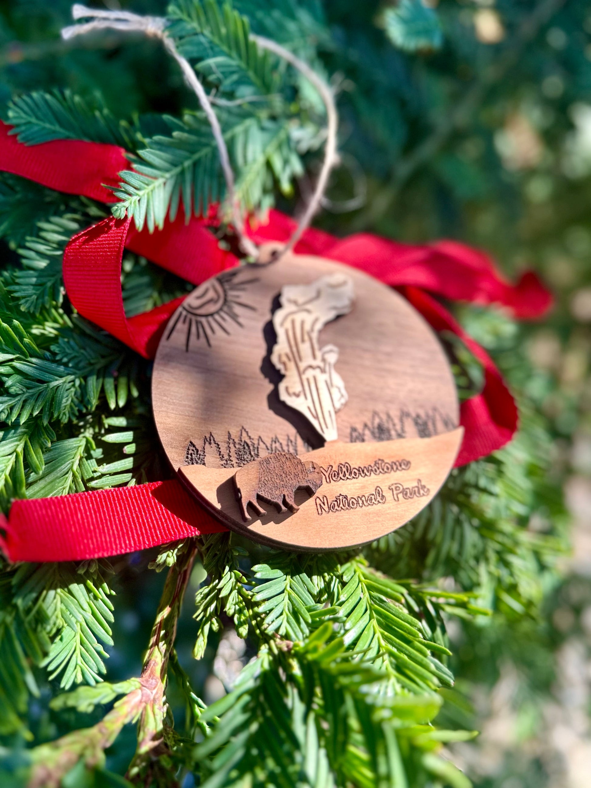 Wooden ornament with a silhouette design hanging on a Christmas tree.