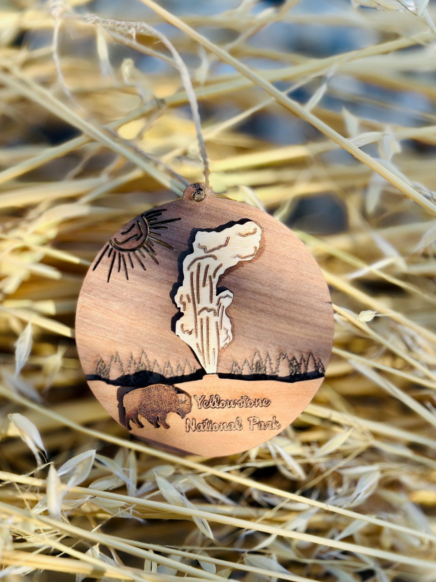 Wooden ornament with laser-cut designs on a straw background