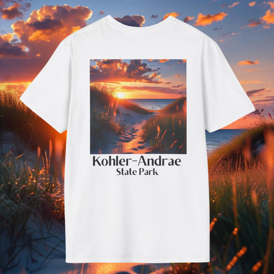 White T-shirt featuring a back design of looking through the sand dunes at a colorful sunrise over Lake Michigan and the text: Kohler-Andrae State Park.  Photo Background: a vivid sunrise above the sand dunes and Lake Michigan.