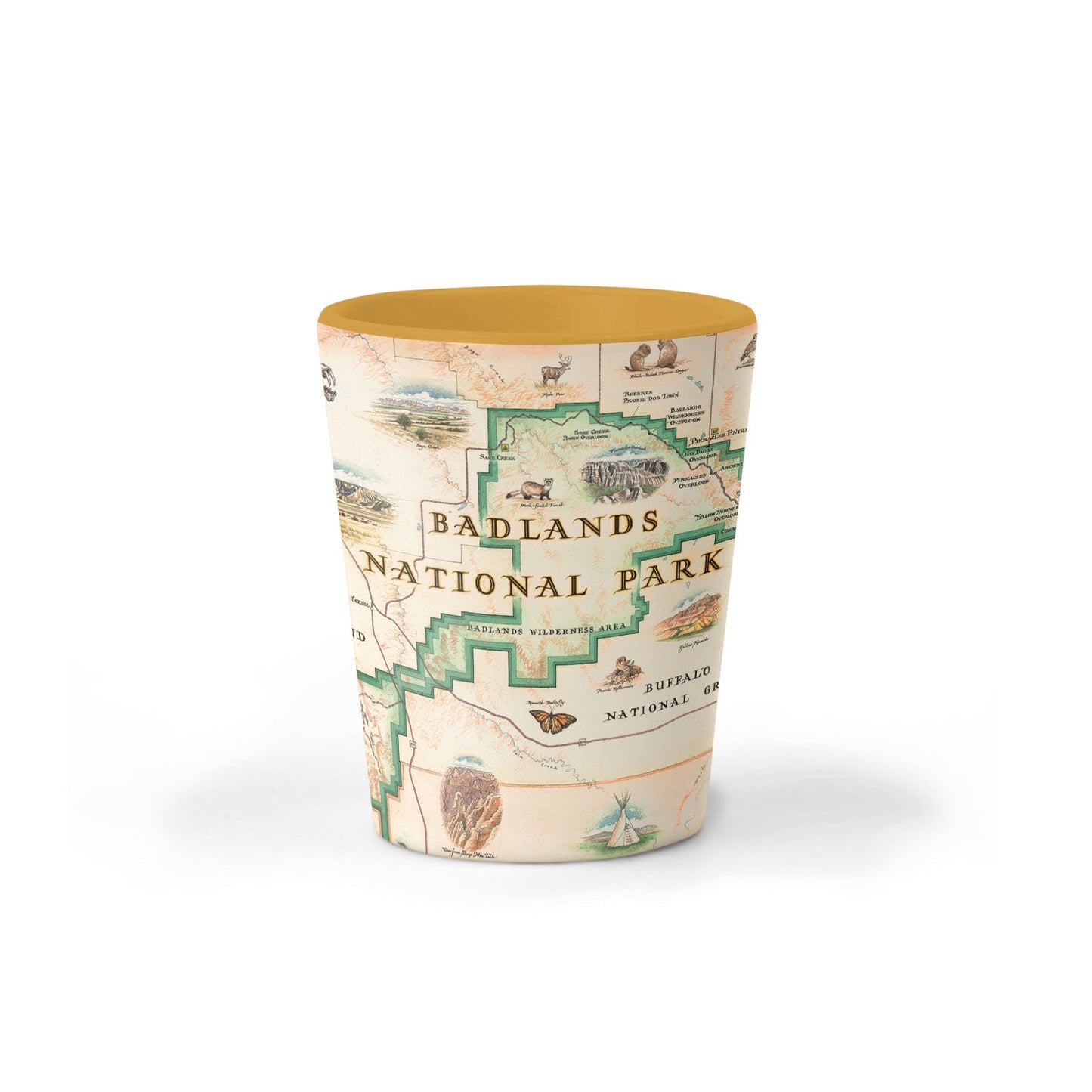A tapered shot glass featuring a vintage-style map print of Badlands National Park with illustrated details and text, finished with a solid mustard yellow rim, shown on a white background.