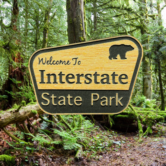 Engraved wood grain acrylic with “Welcome to Interstate State Park”.  Photo background: Dense forest. 