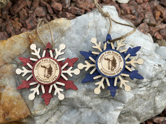 Blue and red wood snowflake ornaments with text Copper Falls and waterfall symbol. 