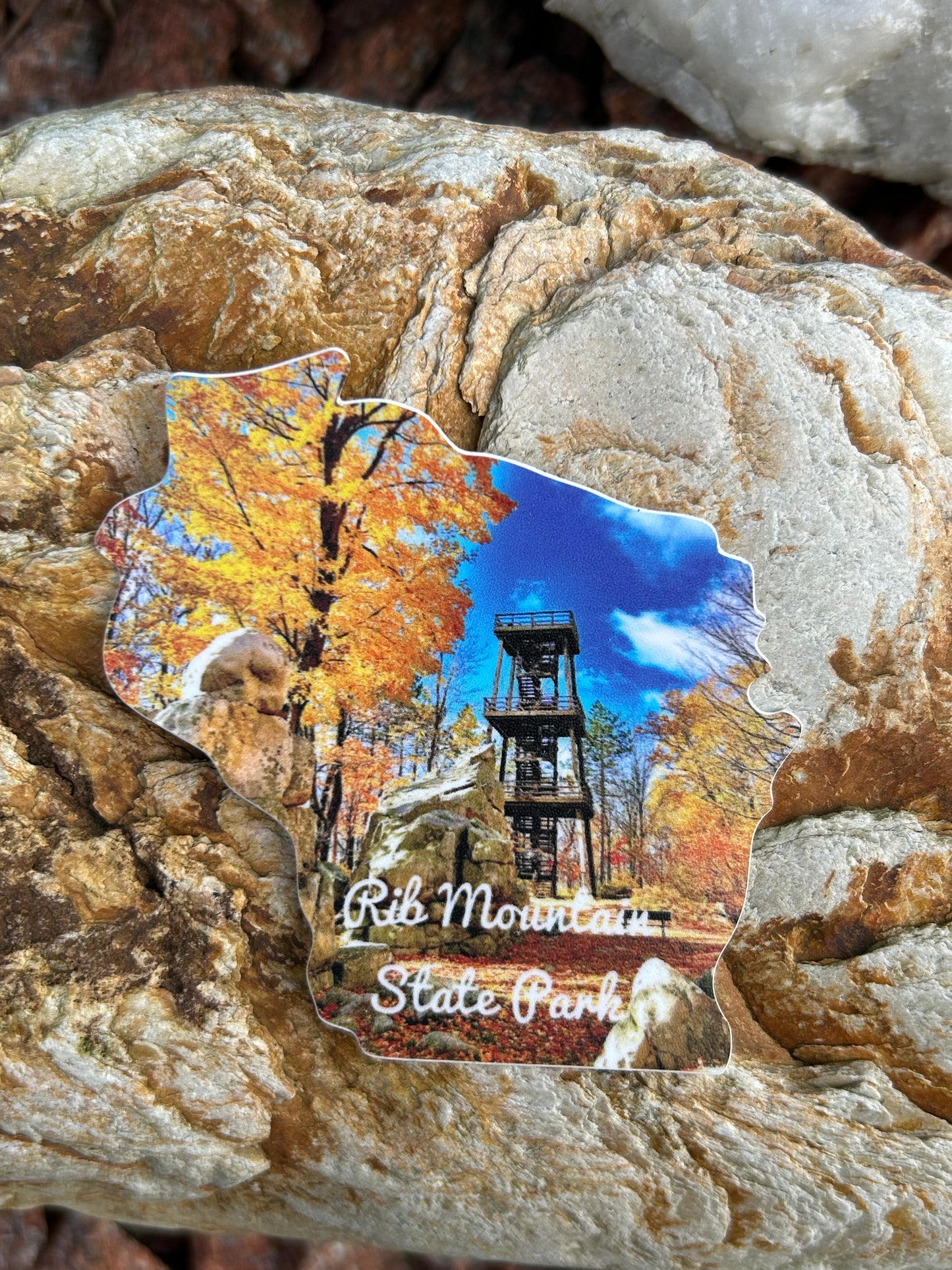 Wisconsin Shaped sticker with a photograph of fall color trees and observation tower, and the text "Rib Mountain State Park". 