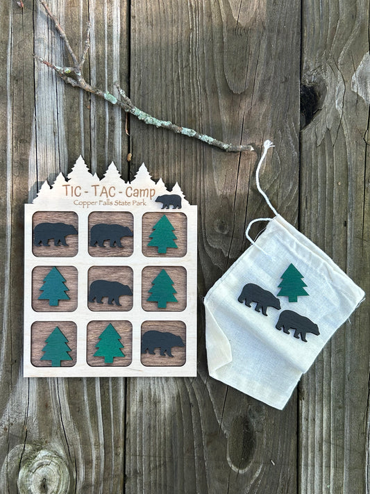 Wood tic tac toe game board with bear and tree shaped game pieces and cloth game piece storage pouch. 