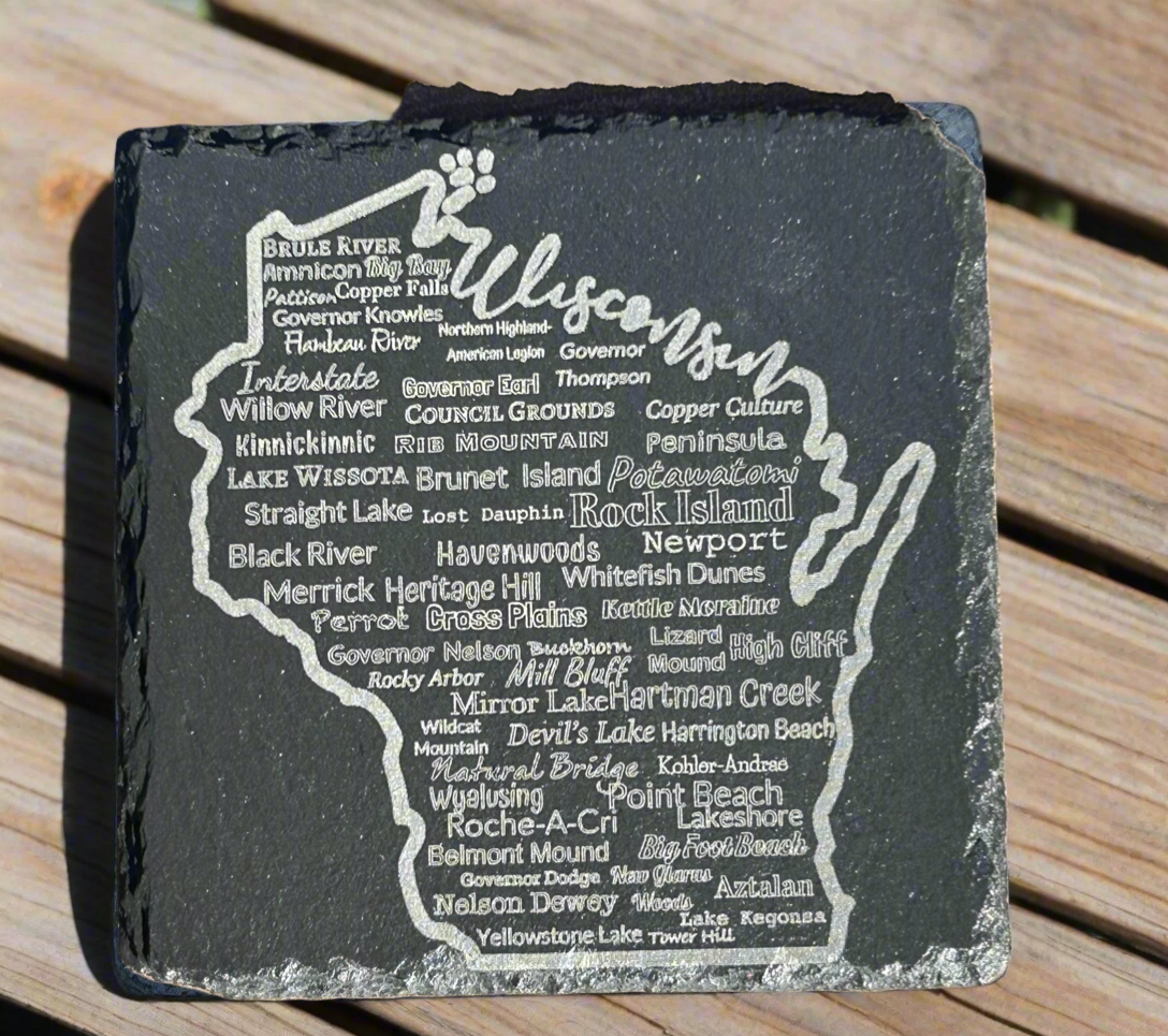 Slate coaster with engraved text of Wisconsin parks on a wooden surface