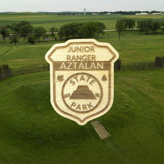 Wood Jr Ranger badge with the text: Junior Ranger, Aztalan State Park.  Photo background: mound at Aztalan State Park.