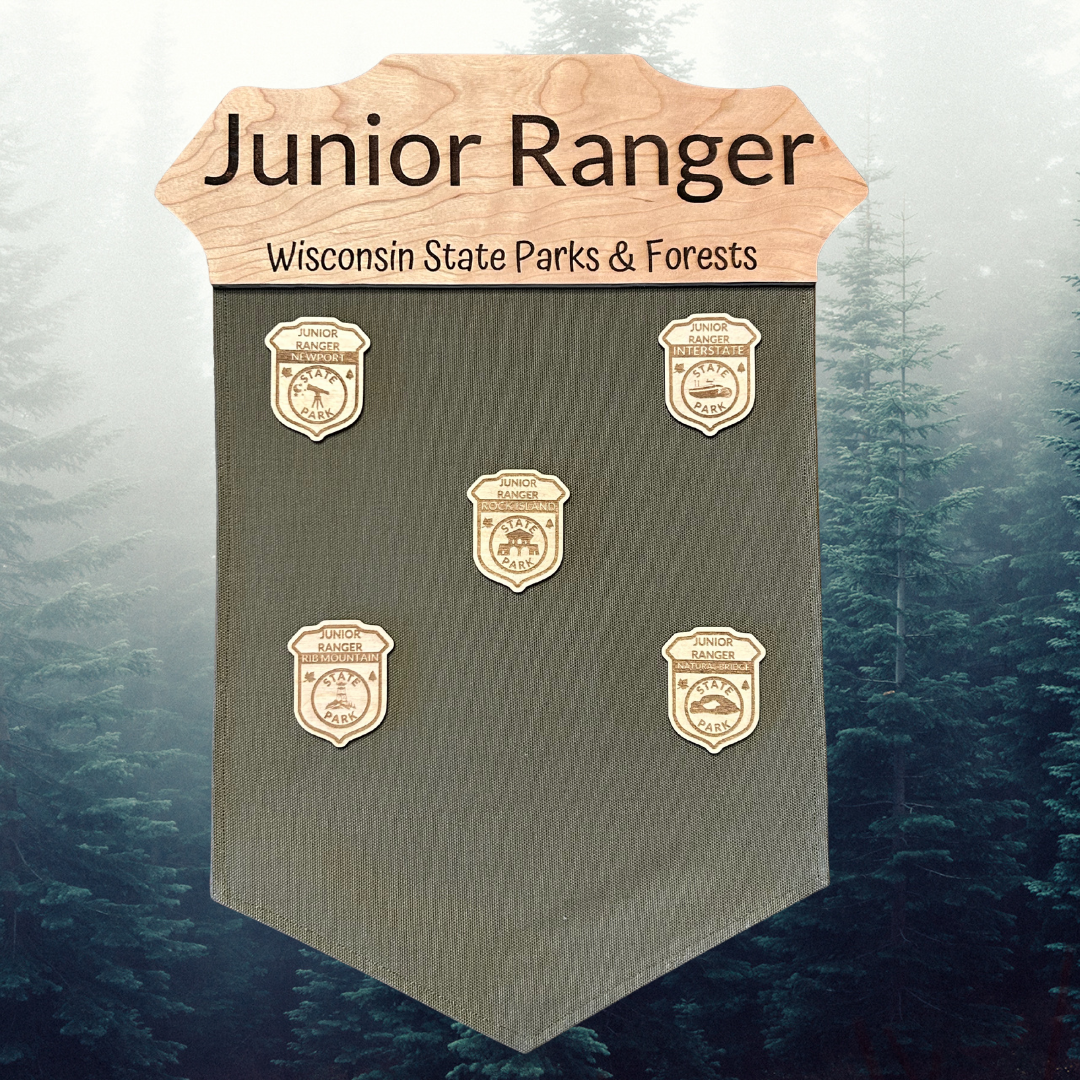 Jr. Ranger banner with cherry wood badge top and green duck canvas banner.  Photo background: misty forest.
