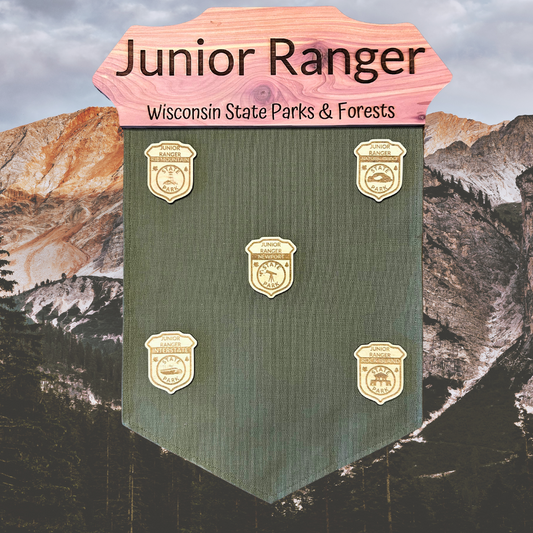 Jr. Ranger banner with cedar wood badge top and green duck canvas banner.  Photo background: Mountains at twilight.