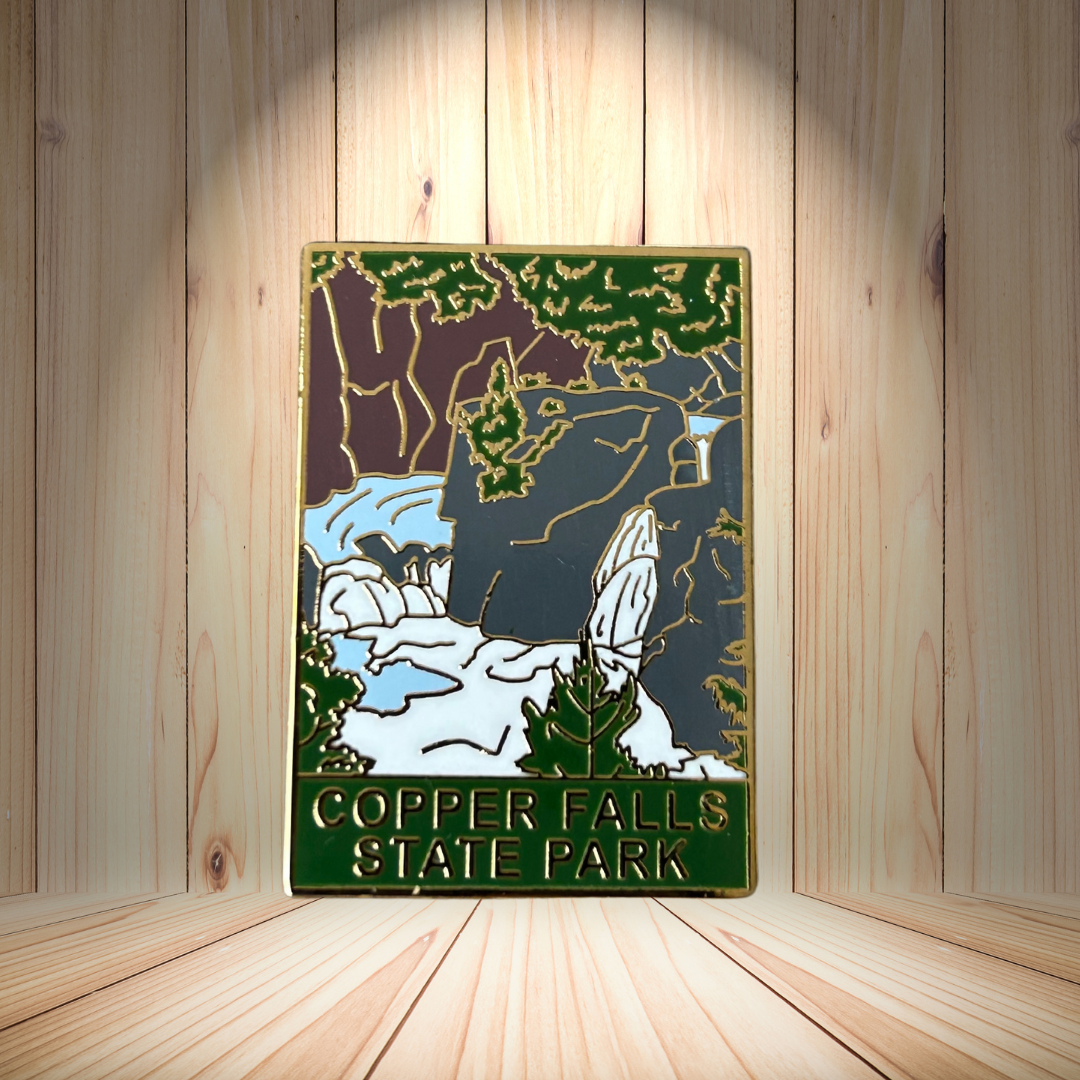 Hard enamel pin depicting Copper Falls at Copper Falls State Park.  Photo background: rough sawn wood and downlight.