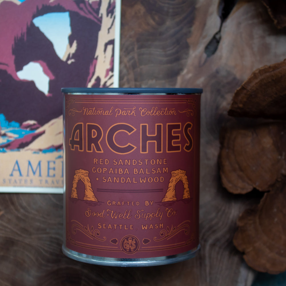 Candle in a decorative can labeled 'Arches' with a national park theme.