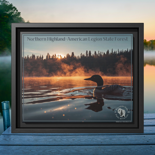 Black framed canvas art depicting a loon swimming on a lake in the early morning as mist rises from the water.  Photo background: looking out over a lake in the early morning as mist rises from the water.