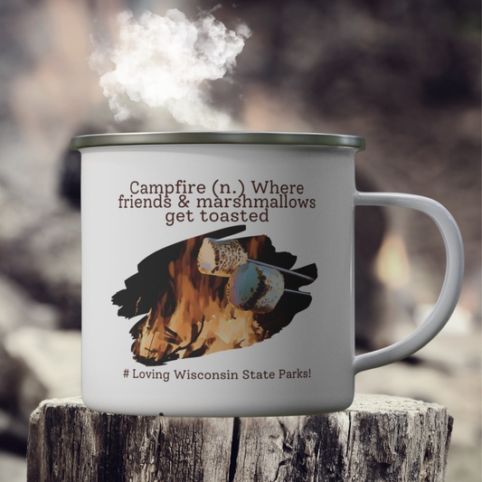 White enamel camper mug on a stump with a graphic design of a marshmallow being roasted over a fire and the text: campfire (n.) where friends and marshmallows get toasted. # loving Wisconsin State Parks”.