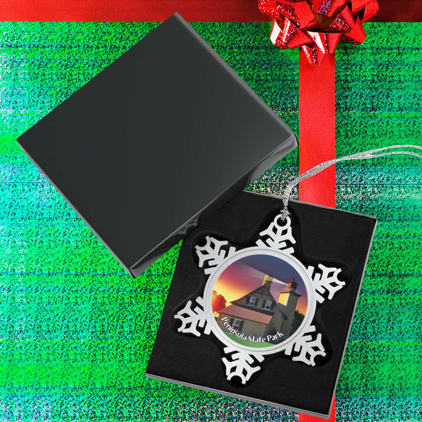 Snowflake-shaped ornament with a lighthouse design in a black box on a green and red striped wrapping paper background