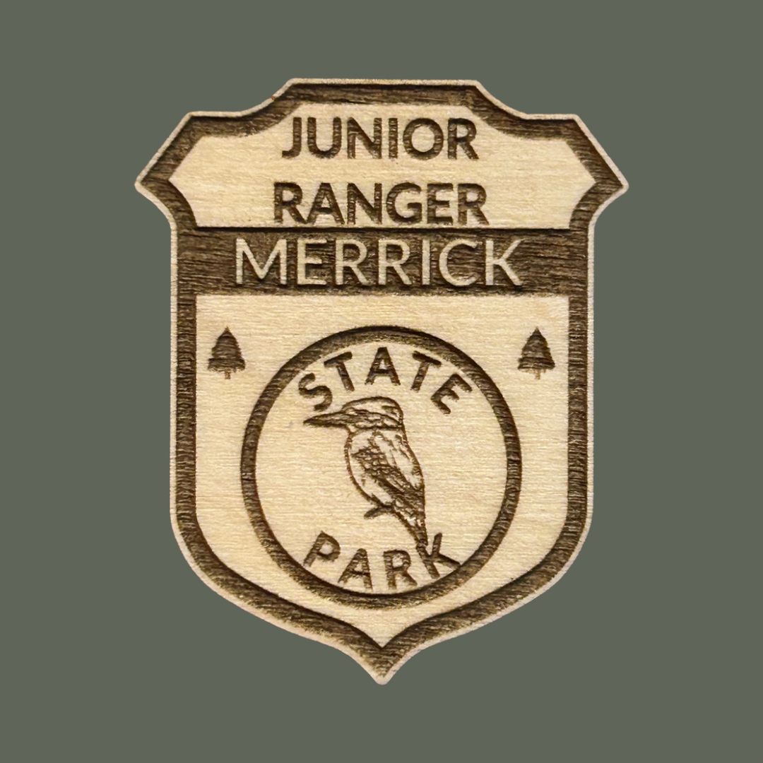 Wooden badge with 'Junior Ranger Merrick State Park' on a gray background