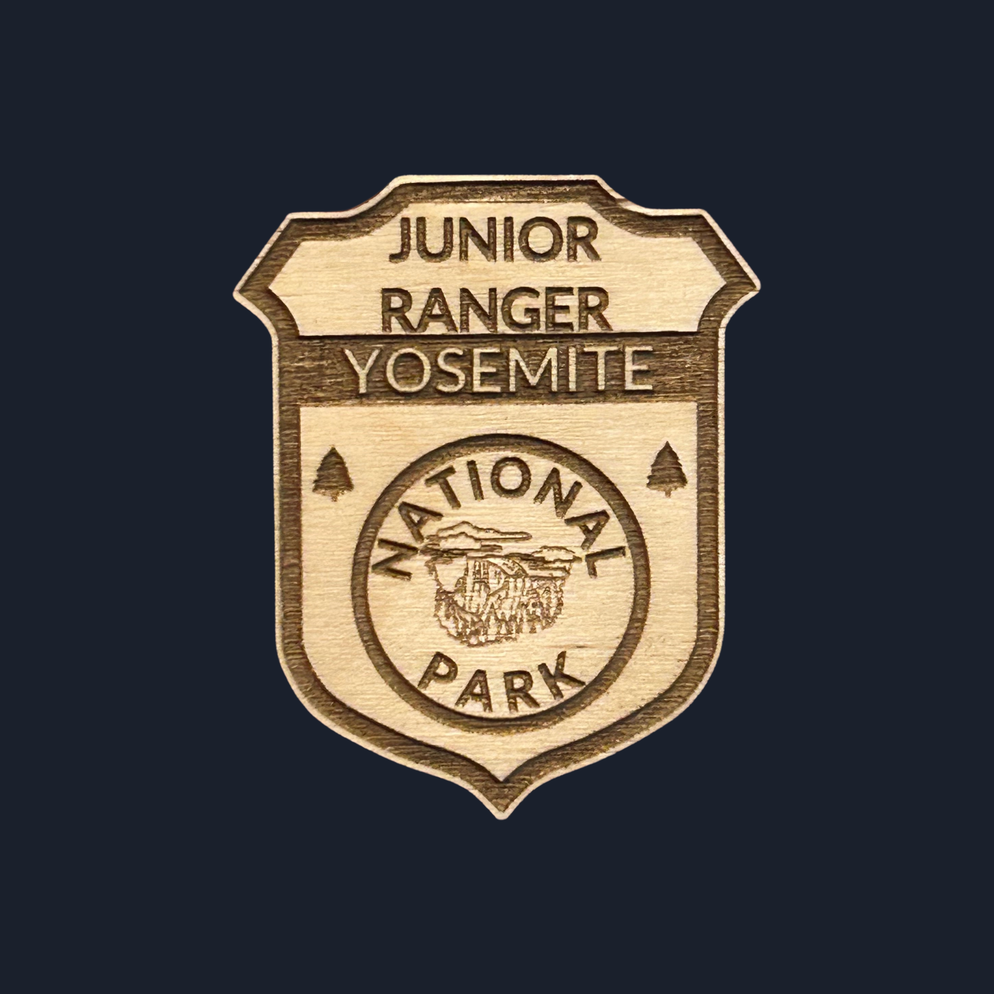 Wooden badge with 'Junior Ranger Yosemite National Park' text on a black background