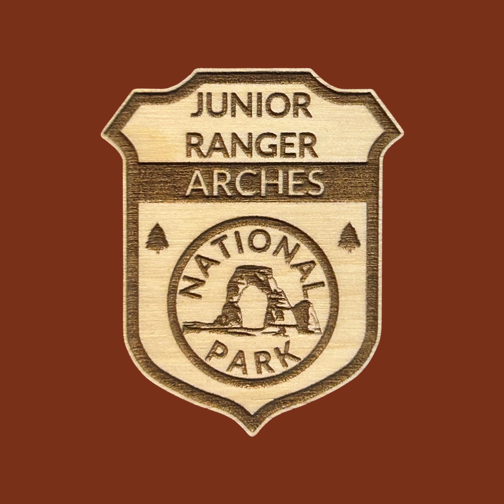 Junior Ranger Arches National Park badge on a brown background