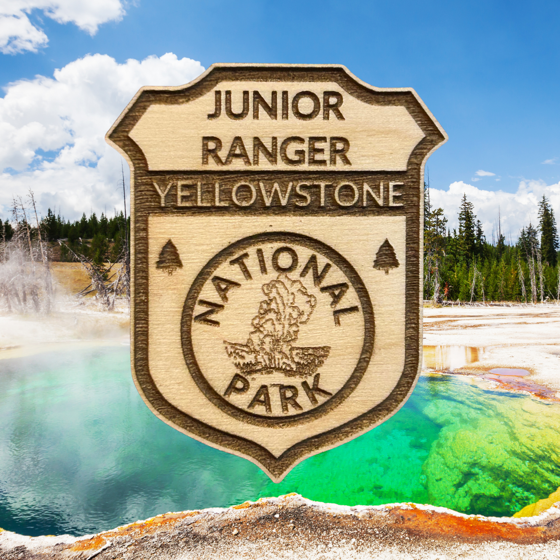 Wood Yellowstone National Park Jr Ranger badge with a thermal pool in the background.