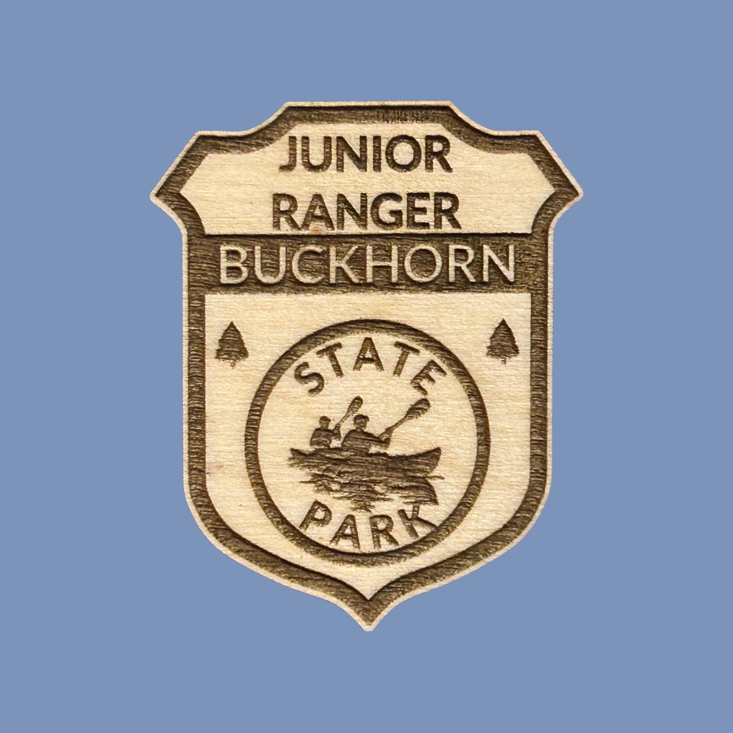 Wood badge with the text: “Junior Ranger Buckhorn State Park” set against a light blue background.