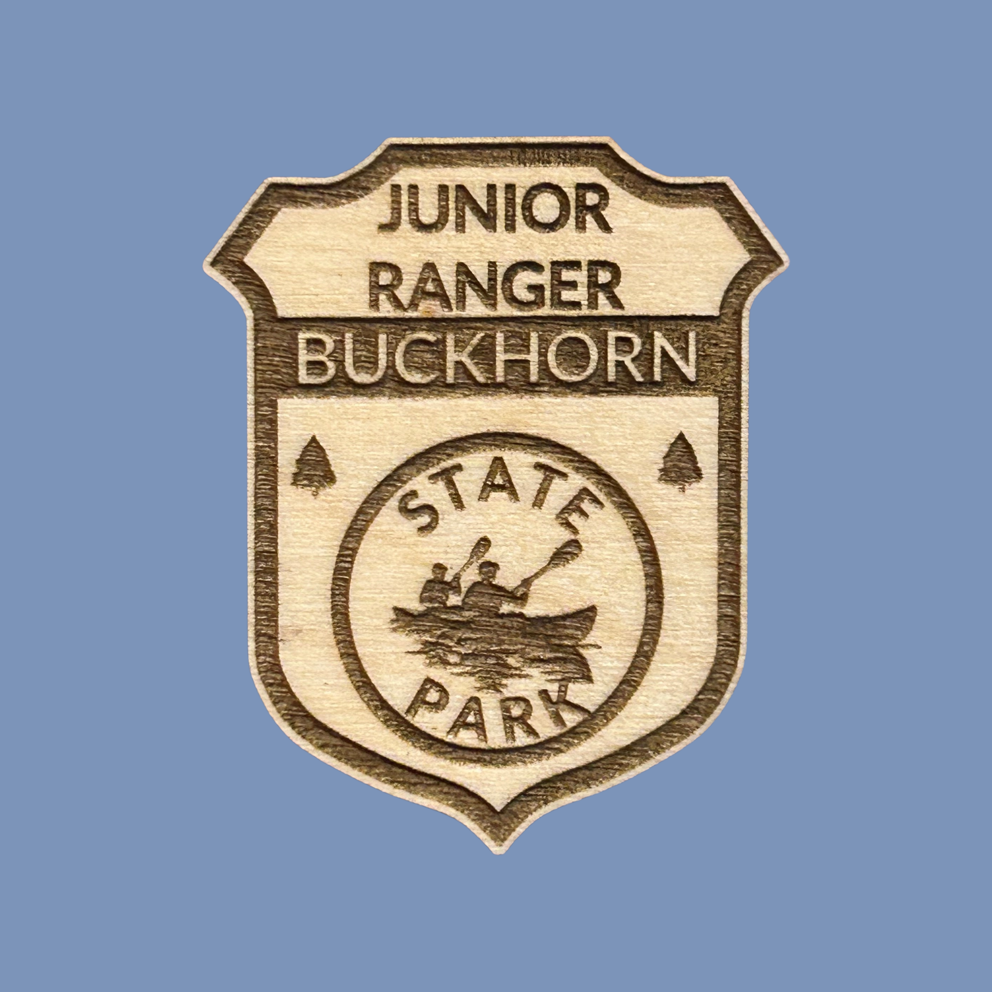 Wood badge with the text: “Junior Ranger Buckhorn State Park” set against a light blue background.