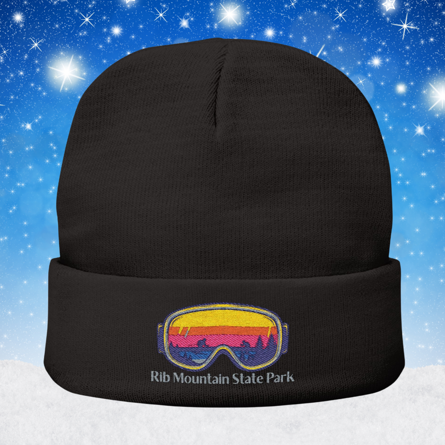 Black beanie with a colorful goggles design and Rib Mountain State Park text on a snowy background