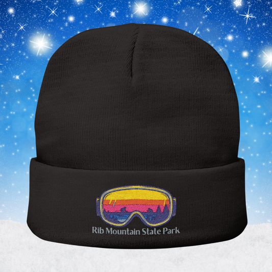 Black beanie with a colorful goggles design and Rib Mountain State Park text on a snowy background
