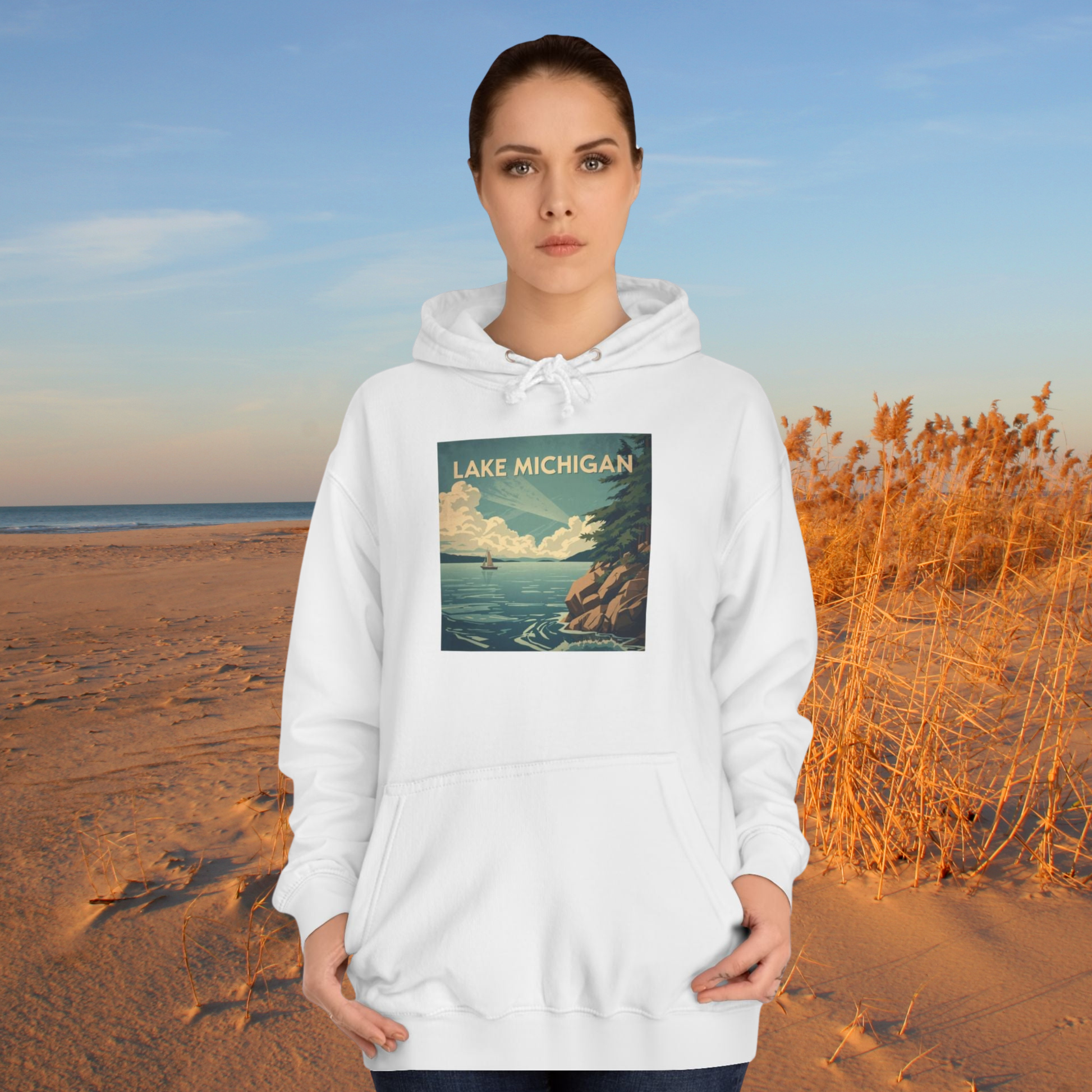 Person wearing a white hoodie with a Lake Michigan design on a beach