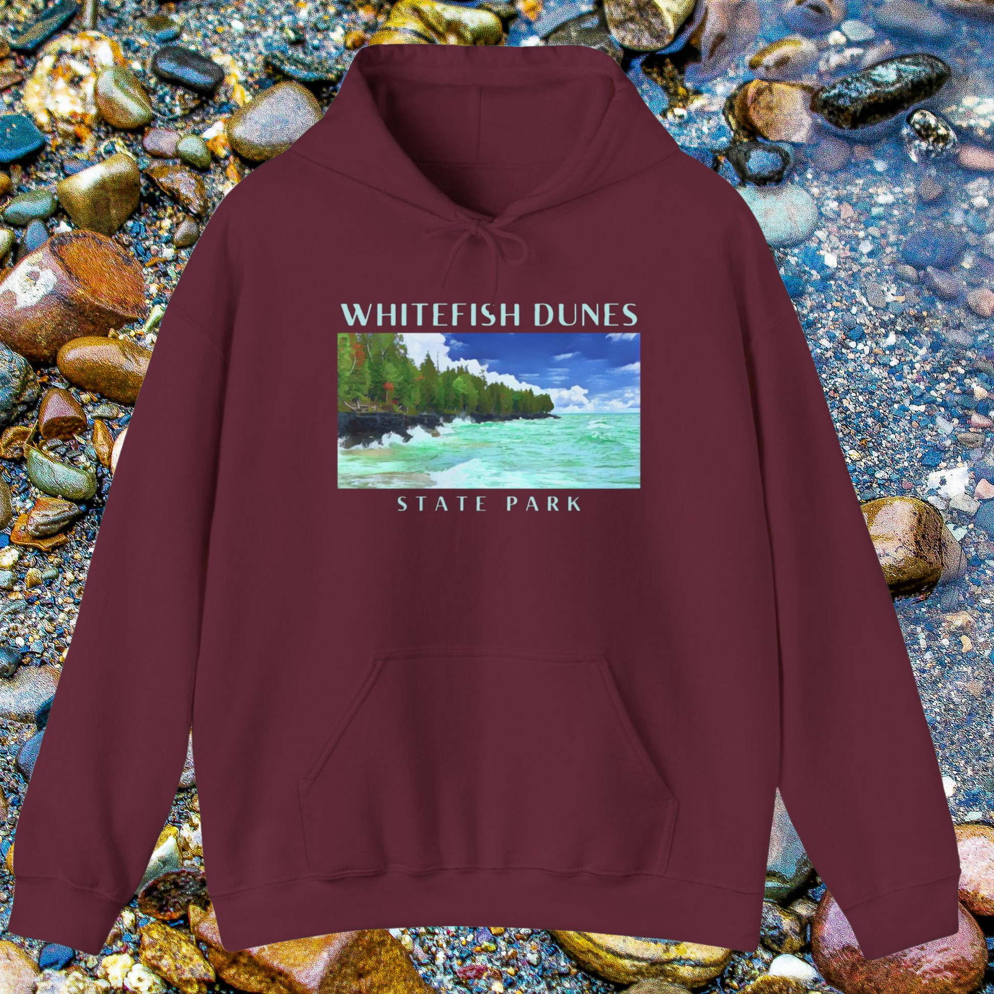 Maroon hoodie with Whitefish Dunes State Park graphic on a pebbly surface