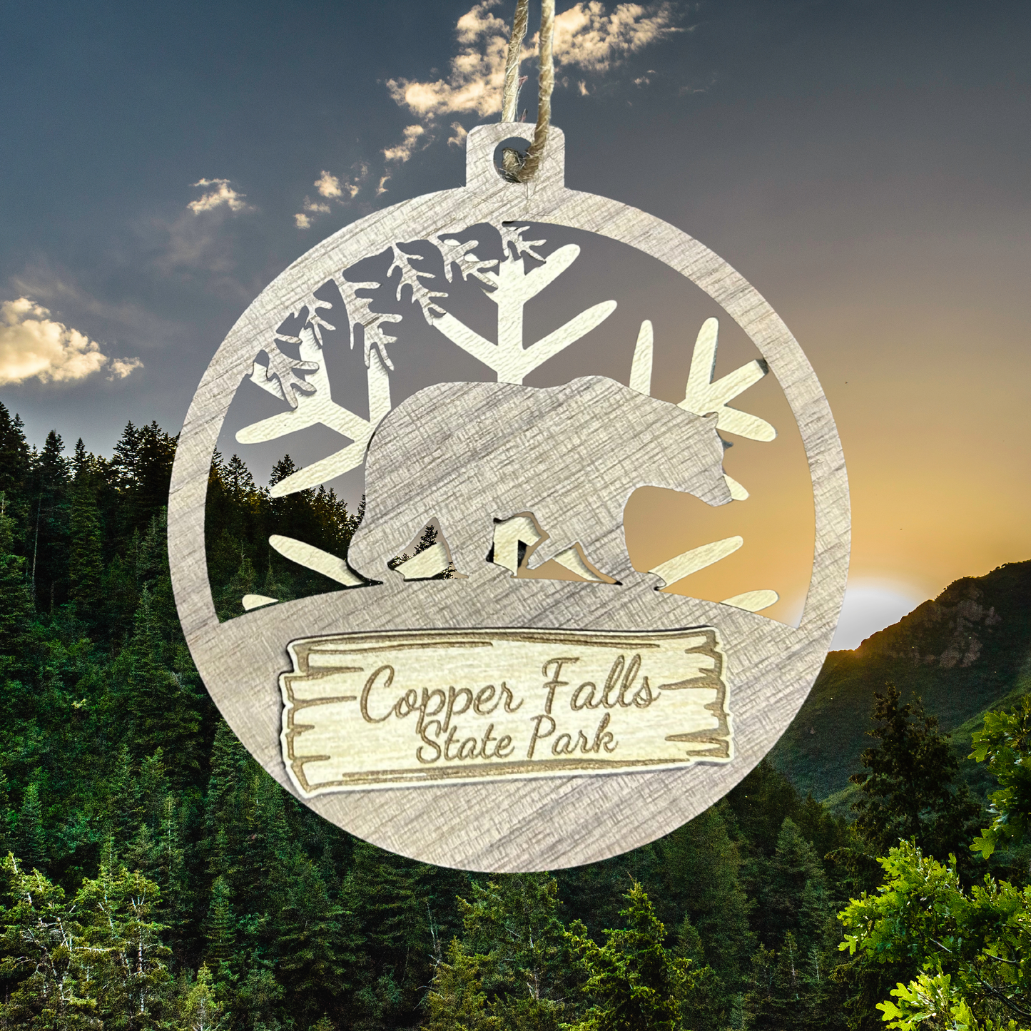 Wood Bear magnet with snowflake background and text "Copper Falls State Park" against a wooded mountain scene.