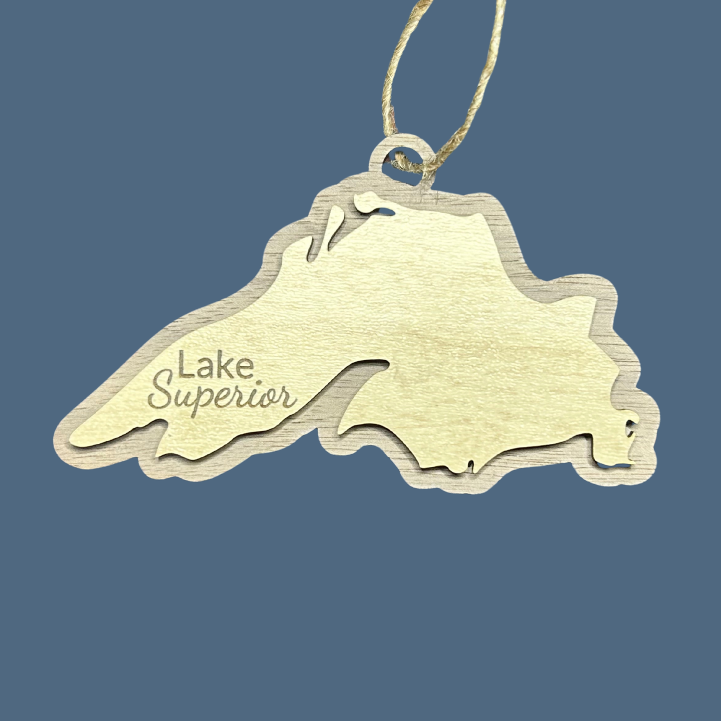 Lake Superior Shaped ornament with a walnut background and the text "Lake Superior" on a blue background.