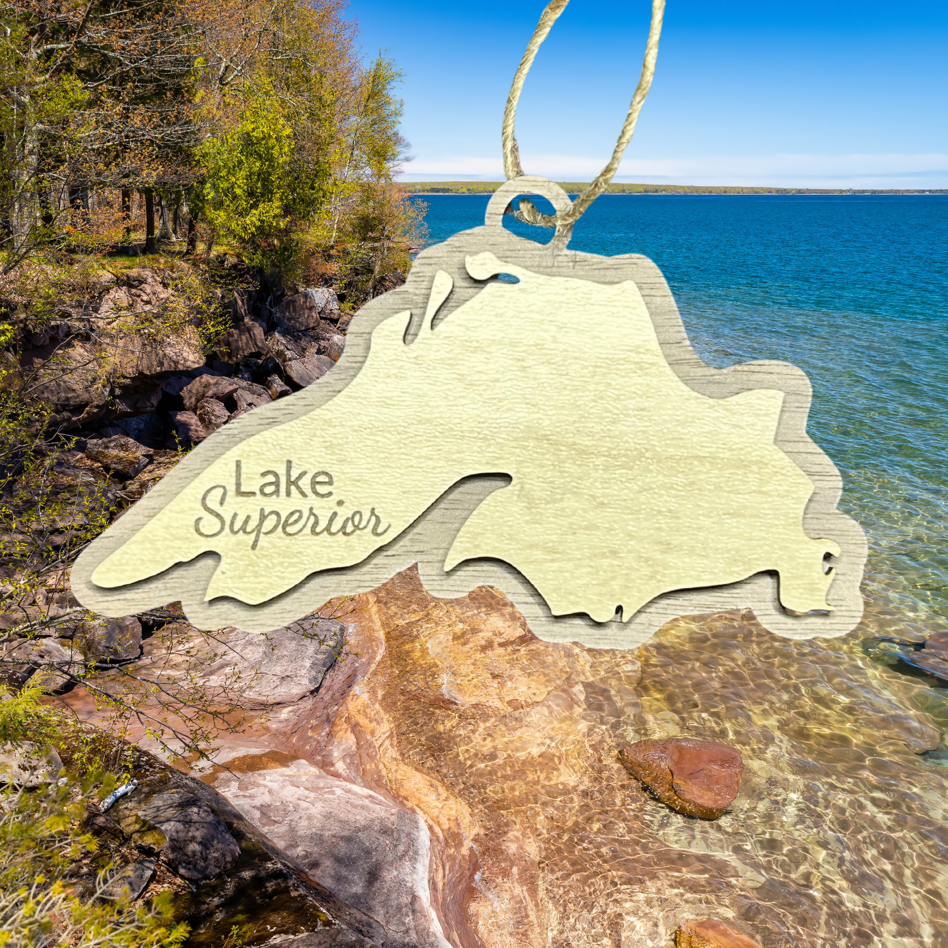Lake Superior Shaped ornament with a walnut background and the text "Lake Superior" against a rugged shoreline.